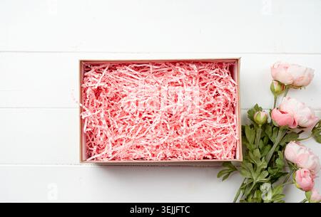Shredded pink paper packing material texture in a craft box, mockup design Stock Photo