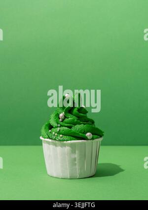 Christmas tree shaped cupcakes on green background Stock Photo