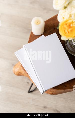 White book blank cover mockup on stylish wooden coffee table with roses bouquet, high angle view Stock Photo