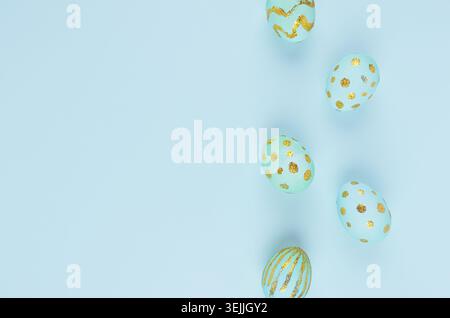 Simplicity and minimal easter background - blue eggs with gold design as border on blue color, top view. Stock Photo