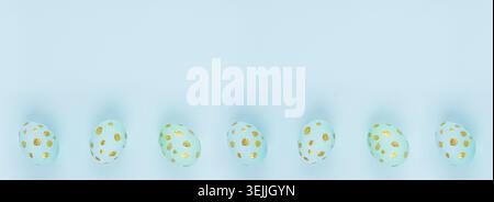 Easter banner - blue eggs with golden dots in row as border on blue backdrop, top view, copy space. Stock Photo