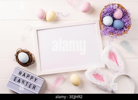 White frame with easter decorations flat lay on beige background Stock Photo