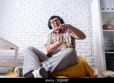 Young man playing video games at home Stock Photo