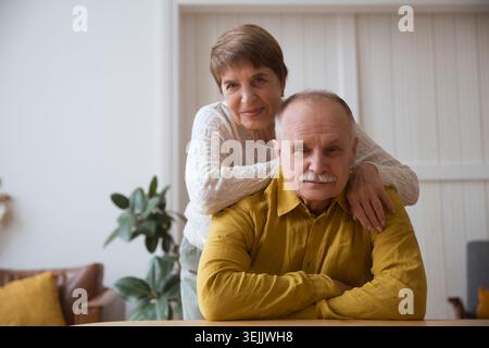 Happy Senior couple looking at camera, smiling talking at webcam saying hello hi making online call vlog in home. quarantine. he Stock Photo