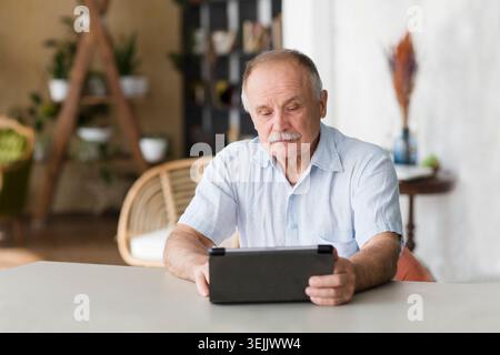 Elderly man using digital tablet  and Communicate online at home. Distancing. copy space. Stock Photo