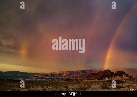 Colorful double rainbow arcing over arid landscape near lake mead, nevada, during sunset Stock Photo