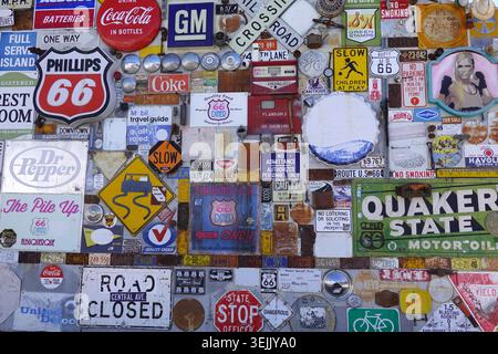A collage of vintage signs and memorabilia on Route 66. Items include Phillips 66 signs, Coca-Cola ads, road and traffic signs, and license plates. Stock Photo