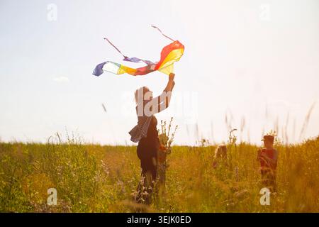 Family mom and kids with a kite in the field at sunset on a summer day Stock Photo