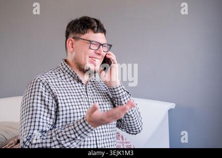 Man sitting on the bed using smartphone having a call Stock Photo