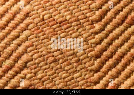 Macro texture of a woven brown wicker rug with a thick textured repeating pattern. Stock Photo