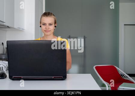 Young smiling woman working with laptop from home Stock Photo