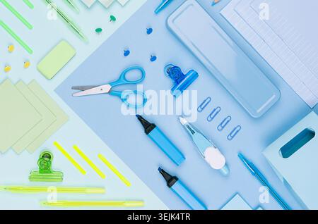 Back to school background - colored different stationery set on soft neon blue, mint green paper background, top view. Stock Photo