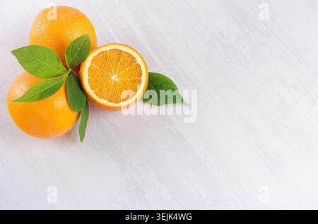 Bright yellow ripe juicy oranges on white wood table, top view, copy space. Stock Photo