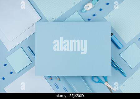 Back to school background - pink boy's different stationery set  and blank paper for text on soft blue paper background. Stock Photo
