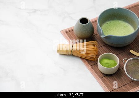 Traditional matcha kit, Bamboo whisk and beverage on bamboo mat in the kitchen Stock Photo