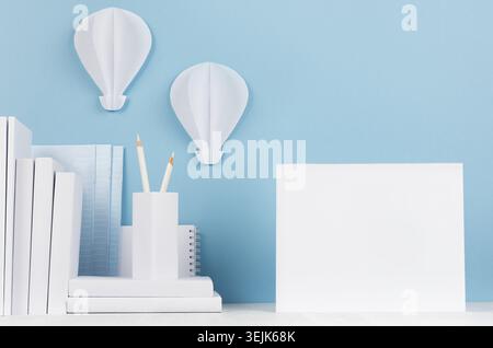 School template -  white books, stationery, blank notebook and decorative ballons origami on white desk and soft blue background Stock Photo