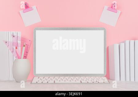 Elegant home workplace with stylish silver blank computer notebook and white stationery, stickers on pink background. Stock Photo