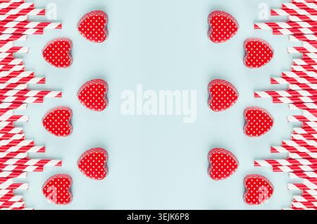 Red valentines and striped straws on mint color paper as decorative abstract festive background for Valentine's day. Stock Photo