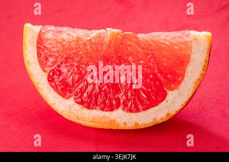 Grapefruit slice isolated on a red background. File contains clipping path. Stock Photo