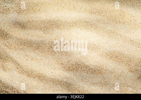 Sea sand texture with ripple patterns resembling underwater surface, ideal as abstract summer background. Stock Photo