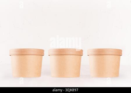 Set of cardboard package for different fast food for advertising, menu, banding identity - three  round containers on white wood Stock Photo