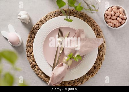 Easter table setting with pink plate and spring decor Stock Photo