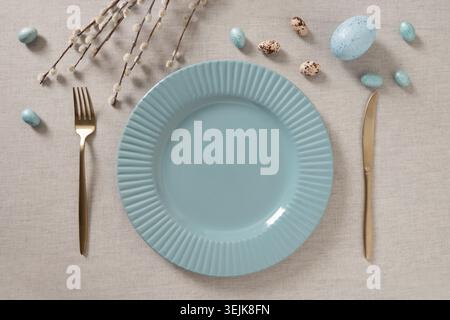 Minimal Easter table setting with empty plate and eggs Stock Photo