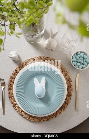 Easter table setting with bunny plate and pastel eggs Stock Photo