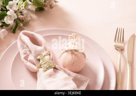 Easter egg decoration with golden bunny napkin ring on table setting Stock Photo