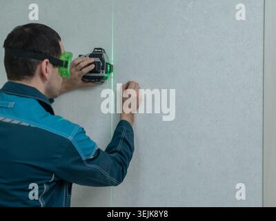A man measures distance with a laser level.  Stock Photo