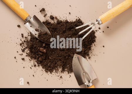 Gardening tools arranged with soil on minimal background Stock Photo