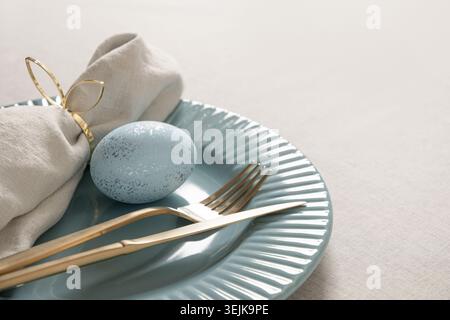 Easter table setting with blue egg and linen napkin Stock Photo