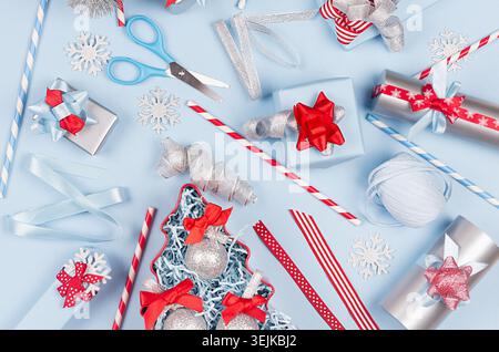 Christmas background - gift boxes in red, blue and silver metallic color with ribbons, decorations, scissors,  straws as pattern Stock Photo