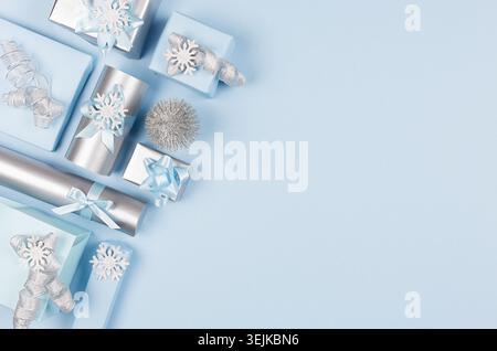 Delicate pastel blue christmas background - various gift boxes with glitter ribbons and bows, small christmas tree as decorative Stock Photo