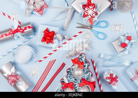 Christmas preparations - festive different gift boxes in red, blue and metallic color with silk ribbons, christmas tree on light Stock Photo