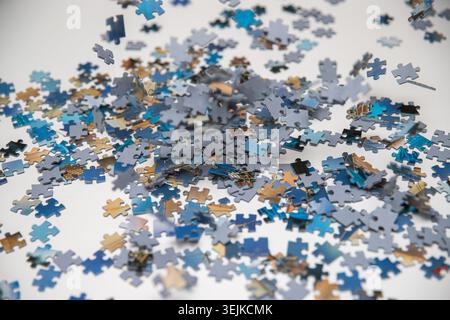 Scattered Blue Jigsaw Puzzle Pieces on White Background Stock Photo