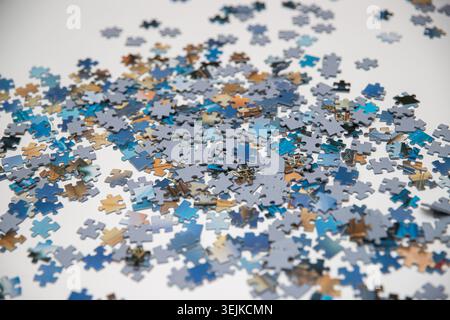 Scattered Blue Jigsaw Puzzle Pieces on White Background Stock Photo