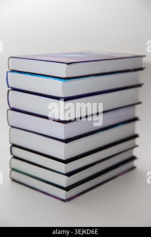 Stack of hardcover books with blank white pages isolated on a light background. Stock Photo