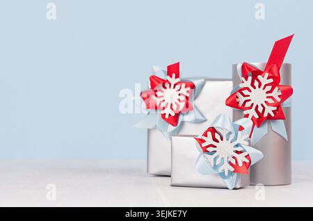 Winter season elegant cold background for advertising and design - silver gift boxes with red and blue silk ribbons, bow, snowfl Stock Photo