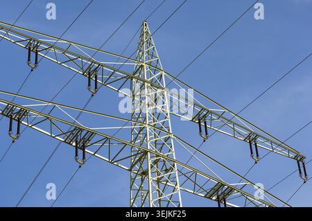 A power pole of an overhead line or power line with cables and insulators viewed from below Stock Photo
