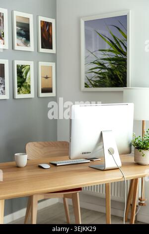 Work from home: cozy workplace for freelancer, programmer with computer, keyboard, mouse and plants Stock Photo