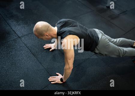 Athletic man doing push ups on gym floor Stock Photo