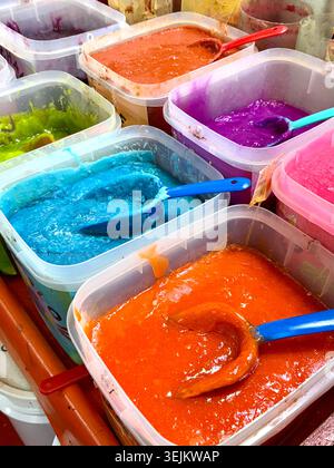 Brightly colored flavored pastes and syrups displayed in plastic tubs at Mercado de La Merced in Mexico City, Mexico Stock Photo
