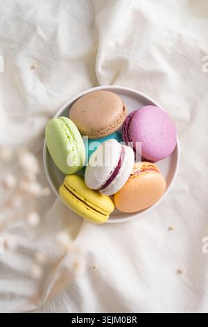 Colorful macaroons on the plate on the bed Stock Photo