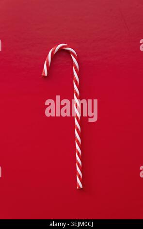 White and red candy cane isolated on red background Stock Photo