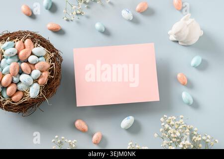 Easter blank for greetings with chocolate sweets as eggs, nest, and bunny. Stock Photo