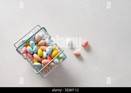 Easter composition with colorful chocolate eggs in shopping cart. Stock Photo