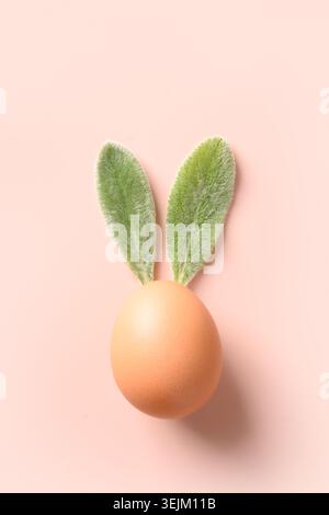 Easter brown egg with from leaves as bunny. Creative Easter card. Stock Photo