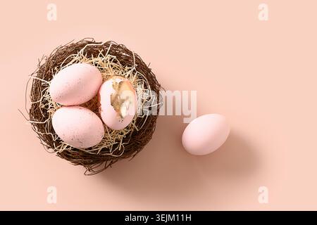 Easter eggs in nest on pink background. Stock Photo