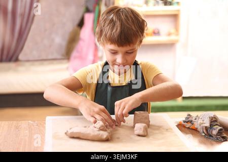 Kids molded from clay at pottery class. Stock Photo
